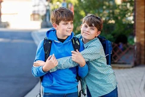 Two kid boys with backpack or satchel. Schoolkids on the way to school. Healthy Stock Photos