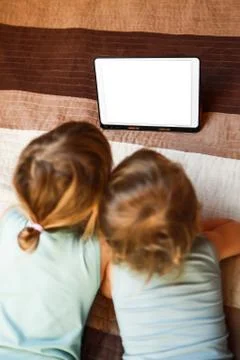 Two kids on the bed with tablet Stock Photos