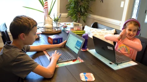 Two kids do virtual learning on laptop Stock Footage 127590995