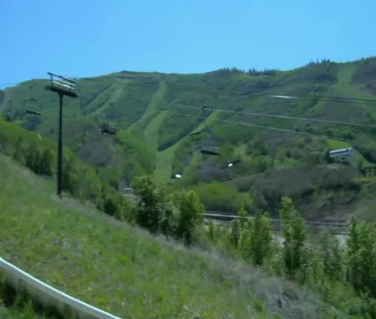 Two kids go down a mountain slide in Summer Stock Footage 21671436