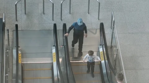 Two kids having fun on escalator. Kids trying to get on wrong side of escalator Stock Footage 127235567