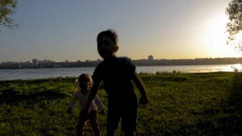 Two kids jumping silhouettes in backlight Stock Footage 121658272