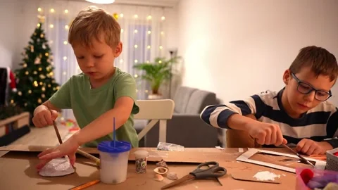 Two kids making handmade decorations from cardboard Stock Footage 297907155