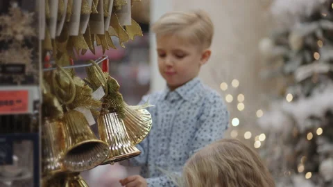 Two kids picking up Christmas tree decoration toys for Christmas in a store Stock Footage 166265610
