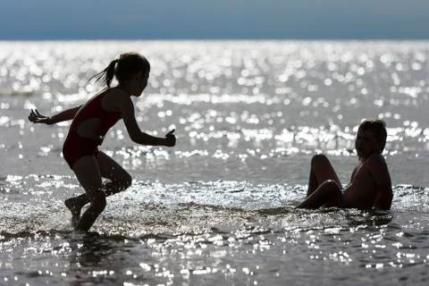 Two kids play at the beach. Stock Photos