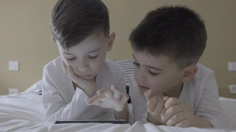 Two kids play with a smartphone Stock Footage 128712237