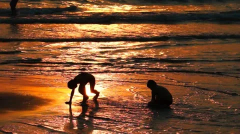 Two Kids Playing on the Beach at Sunset Stock-Footage 22007807