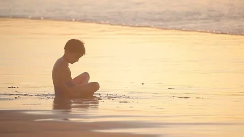 Two kids playing on the beach at sunset Vídeos de archivo 148625249