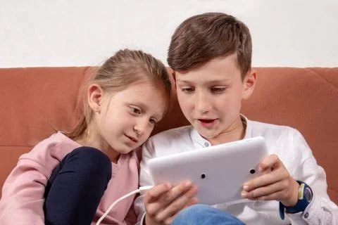 Two kids playing with digital tablet Stock Photos