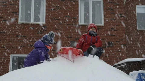 Two kids playing with each other on a snowy day Video stock 149458381