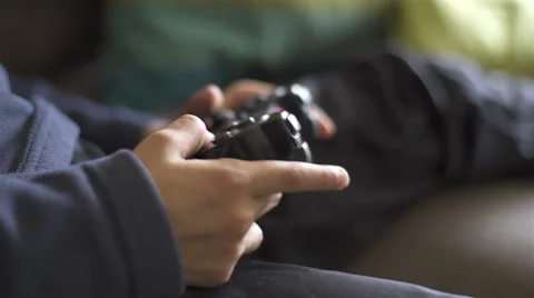 Two kids playing video games. Close Up of hands with controller Видео 62653843