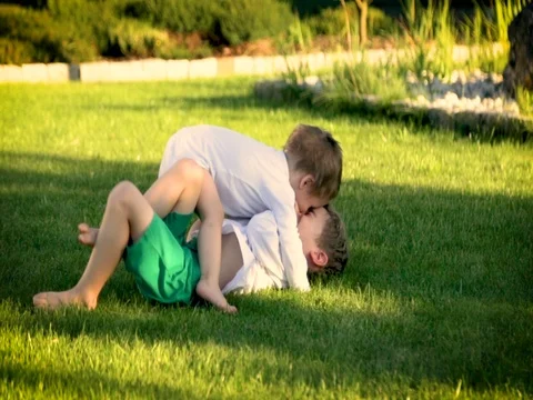Two kids roll and run in the garden Stock Footage 80967361