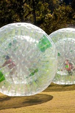 Two kids roll around inside zorbs Foto stock