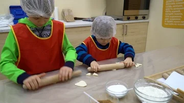 Two kids rolling dough Stock Footage 85896046