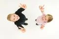The two kids show two finger on the white background. View from above Photo