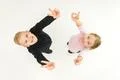 The two kids show two finger on the white background. View from above Photo