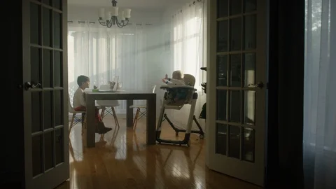 Two kids sitting on the dining table at home Stock Footage 119992551