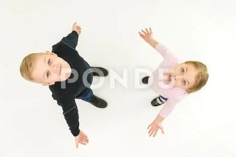 The two kids stand on the white background. View from above Stock Photos