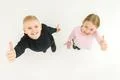 The two kids thumb up on the white background. View from above Photo