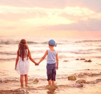 Two kids watching sunset. Stock Photos