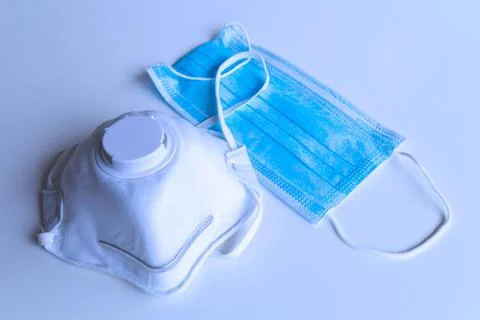 Two kind of protective disposable face masks on gray background. Medical resp Stock Photos