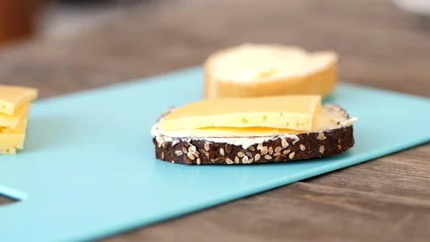 Two Kinds Of Slice Bread With Thick Slice Of Cheese On Top Of The Chopping 스톡 동영상 128982584