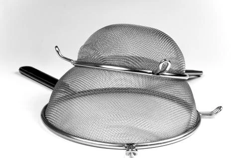 Two kitchen sieves on white background, decoration Stock Photos