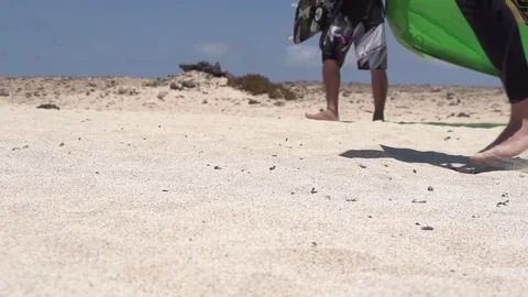 Two kite surfers walking on the beach on a sunny day in slow motion Stock Footage 77810433