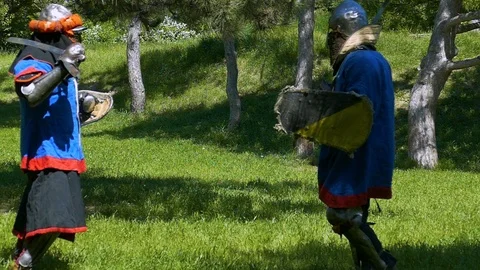 Two knights simultaneously strike each other and block blows with a shield Stock Footage 122079835