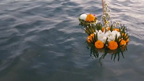 Two krathongs float together in the middle of the sea on the full moon day of th Stock Footage 256654995