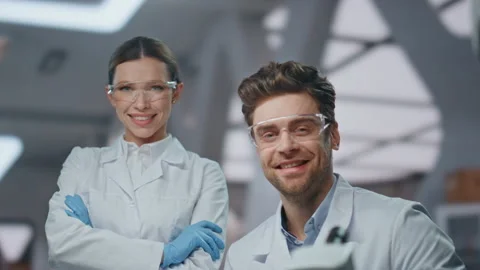 Two lab colleagues smiling to camera in clinic close up. Successful scientists Stock Footage 254615607