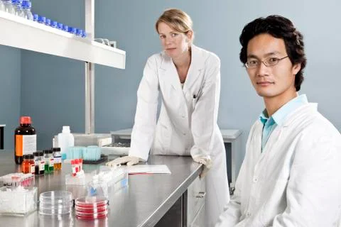 Two lab technicians in a laboratory, looking at camera Stock Photos