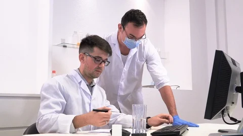 Two lab workers research microbiology and chemistry with pharmaceuticals Stock Footage 117405108