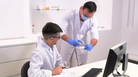 Two lab workers research microbiology and chemistry with pharmaceuticals Видео 117933386
