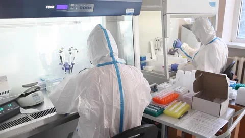 Two laboratory assistants work in the laboratory in protective suits Stock Footage 141883892
