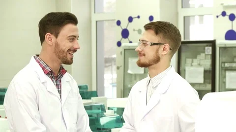 Two laboratory technicians communicate on working subjects Stock Footage 84869023