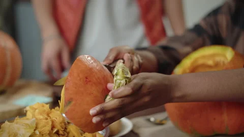 Two ladies are cutting lids of the halloween pumpkins Stock Footage 170462148
