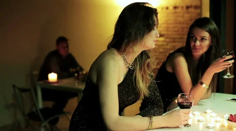 Two ladies chatting and drinking wine by the table Stock Footage 37122774