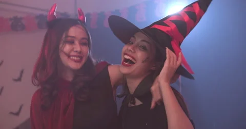 Two ladies in halloween costume dancing to music at house party together. 库存影片 139829341