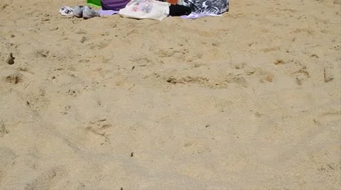 Two ladies sit on sandy beach Stock Footage 21545581