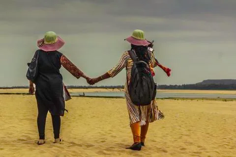 Two lady turning their back in travel mood on sands river bed beach Stock Photos