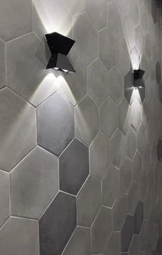 Two lamps on the wall with hexagonal tiles. Stock Photos