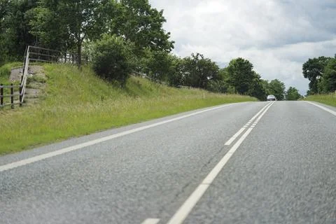 Two lane road with solid right edge and dashed left line Stock Photos