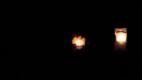 Two lanterns floating on the water at night. Stock-Footage 77231068