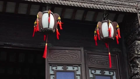 Two lanterns hang outside a building with intricate carvings and traditional Stock Footage 326387729