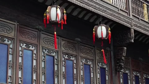 Two lanterns hang outside a building with intricate carvings and traditional Video stock 326387825