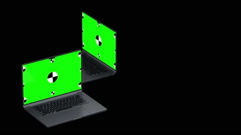 Two laptop revolves around on a black background. Green screen with marks for Video stock 171382019