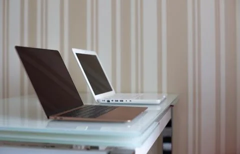 Two laptops on the glass table Stock Photos