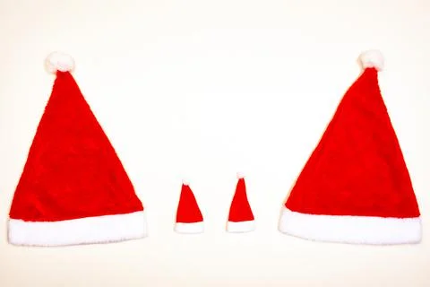Two large and two small Christmas hats on a white background, concept, copy Stock Photos