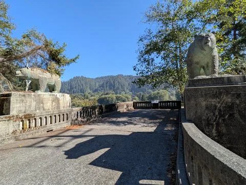 Two large black bear stone carvings stand on a historic bridge Fotos Stock